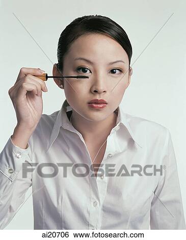 Young woman applying mascara View Large Photo Image Stock Photograph - Young woman applying mascara. Fotosearch