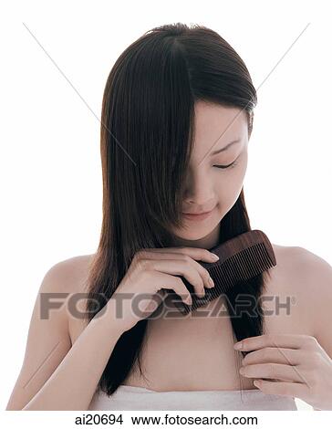 Young woman combing her hair View Large Photo Image Picture - Young woman combing her hair. Fotosearch