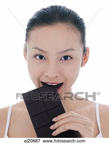 Young woman eating a bar of chocolate View Large Photo Image Stock Photo - Young woman eating a bar of chocolate. Fotosearch