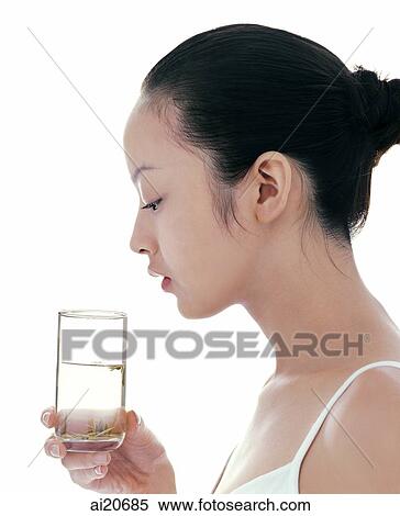 Stock Photography - Young woman looking at glass of water. Fotosearch