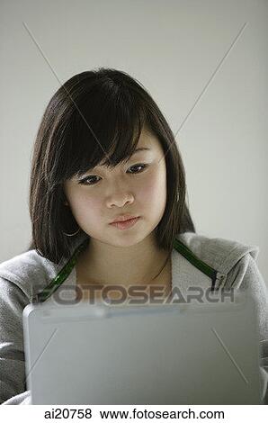 Young woman looking at laptop View Large Photo Image Stock Photo - Young woman looking at laptop. Fotosearch