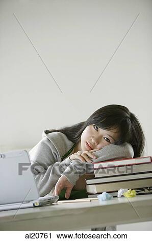 Young woman resting on stack of books, looking at camera View Large Photo Image Stock Image - Young woman resting on stack of books, looking at camera. Fotosearch