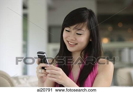 Young woman using mobile phone, text messaging View Large Photo Image Stock Image - Young woman using mobile phone, text messaging. Fotosearch