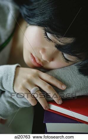 Young woman with head on stack of books, sleeping View Large Photo Image Stock Image - Young woman with head on stack of books, sleeping. Fotosearch