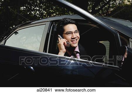 Businessman in car, using mobile phone View Large Photo Image Stock Image - Businessman in car, using mobile phone. Fotosearch
