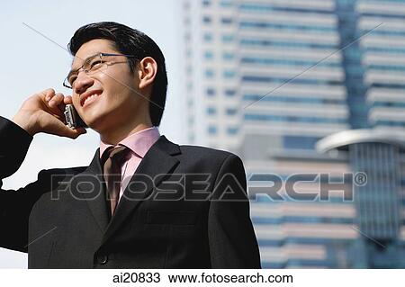 Businessman in city using mobile phone View Large Photo Image Stock Image - Businessman in city using mobile phone. Fotosearch