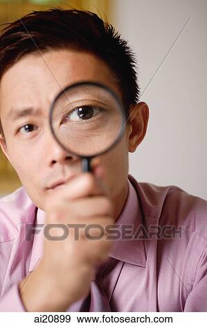 Businessman looking through magnifying glass View Large Photo Image Stock Photo - Businessman looking through magnifying glass. Fotosearch