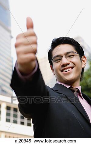 Businessman making thumbs up sign View Large Photo Image Stock Photography - Businessman making thumbs up sign. Fotosearch