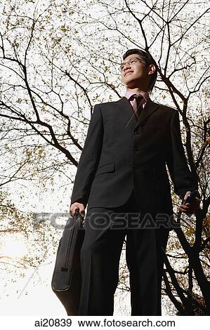 Stock Photo - Businessman outdoors, carrying briefcase. Fotosearch