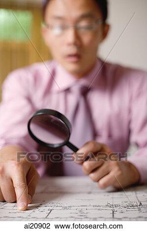 Businessman using magnifying glass, looking at blueprint View Large Photo Image Stock Image - Businessman using magnifying glass, looking at blueprint. Fotosearch