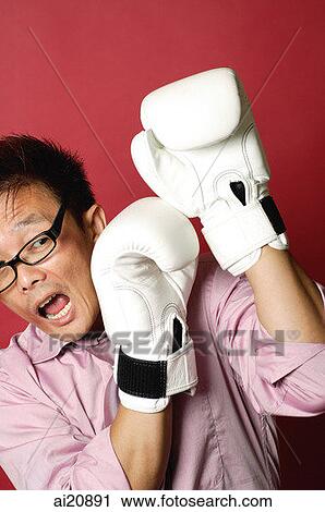 Businessman wearing boxing gloves, shielding face View Large Photo Image Stock Image - Businessman wearing boxing gloves, shielding face. Fotosearch
