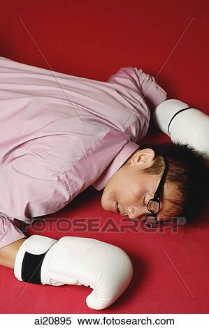 Businessman with boxing gloves, lying on front, knocked out View Large Photo Image Stock Photography - Businessman with boxing gloves, lying on front, knocked out. Fotosearch