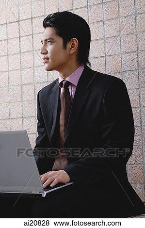 Businessman with laptop, looking away View Large Photo Image Stock Photo - Businessman with laptop, looking away. Fotosearch