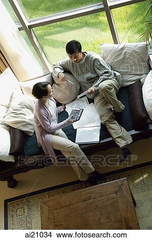 Couple at home doing finances, high angle view View Large Photo Image Picture - Couple at home doing finances, high angle view. Fotosearch