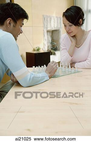 Stock Photography - Couple at home playing chess. Fotosearch