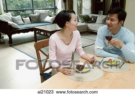 Couple sitting at dining table eating View Large Photo Image Stock Image - Couple sitting at dining table eating. Fotosearch