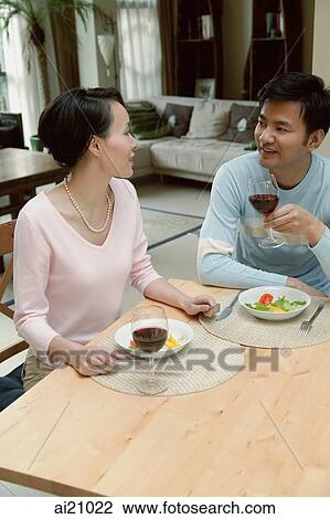 Couple sitting at home having a meal View Large Photo Image Stock Image - Couple sitting at home having a meal. Fotosearch
