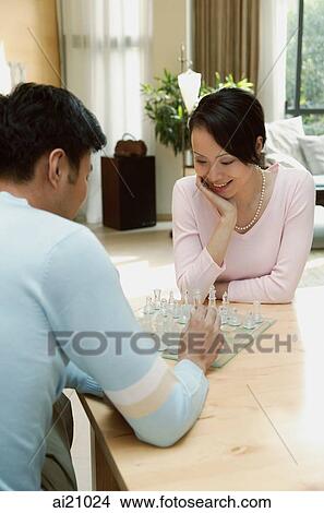 Couple sitting at table at home playing chess View Large Photo Image Picture - Couple sitting at table at home playing chess. Fotosearch