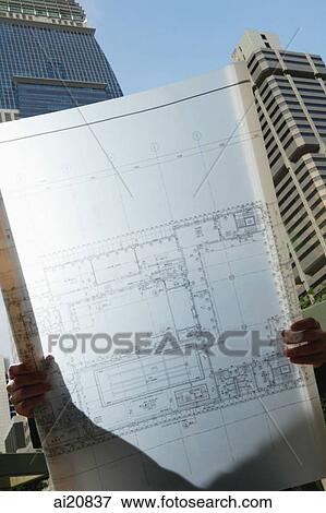 Man holding blueprint, city location View Large Photo Image Stock Photo - Man holding blueprint, city location. Fotosearch
