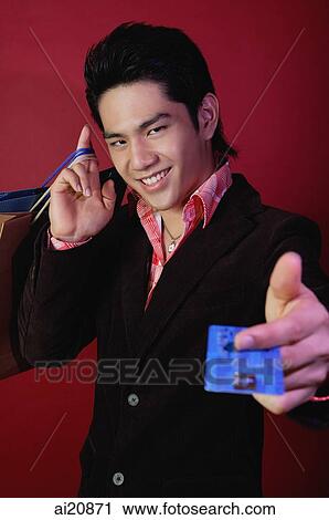 Man holding credit card and shopping bags, looking at camera View Large Photo Image Stock Image - Man holding credit card and shopping bags, looking at camera. Fotosearch