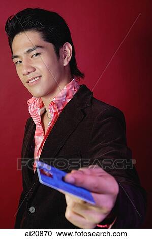 Man holding credit card, looking at camera View Large Photo Image Stock Image - Man holding credit card, looking at camera. Fotosearch