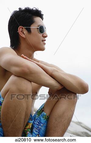 Man sitting with arms crossed, wearing sunglasses, looking away View Large Photo Image Stock Image - Man sitting with arms crossed, wearing sunglasses, looking away. Fotosearch
