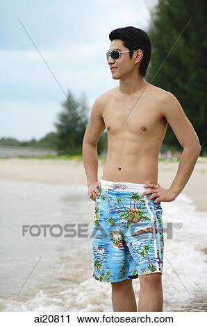Man standing on beach, hands on hips, looking away View Large Photo Image Stock Image - Man standing on beach, hands on hips, looking away. Fotosearch