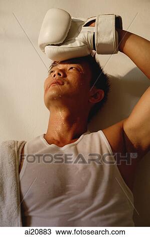 Man wearing boxing glove, hand on head, looking away View Large Photo Image Stock Image - Man wearing boxing glove, hand on head, looking away. Fotosearch
