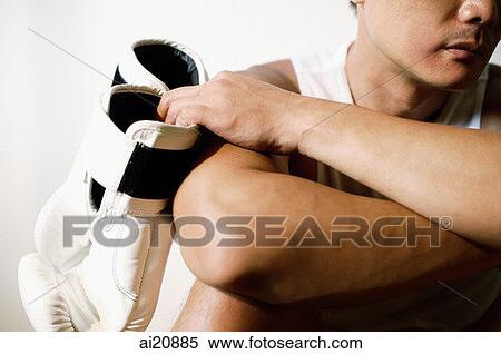 Man with arms crossed, holding boxing gloves, cropped image View Large Photo Image Stock Photography - Man with arms crossed, holding boxing gloves, cropped image. Fotosearch