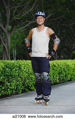Stock Photo - Mature adult with roller blades, standing with hands on hips. Fotosearch