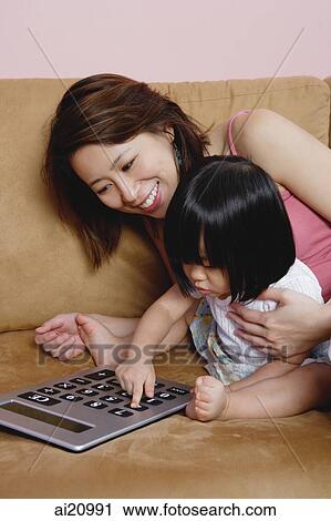 Mother with young daughter, using calculator View Large Photo Image Stock Image - Mother with young daughter, using calculator. Fotosearch