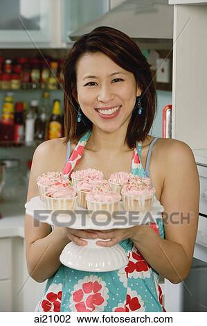 Woman holding tray with cupcakes View Large Photo Image Stock Image - Woman holding tray with cupcakes. Fotosearch