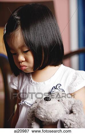 Stock Photo - Young girl holding stuffed toy. Fotosearch