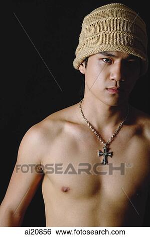 Young man wearing cap and cross necklace View Large Photo Image Stock Photograph - Young man wearing cap and cross necklace. Fotosearch