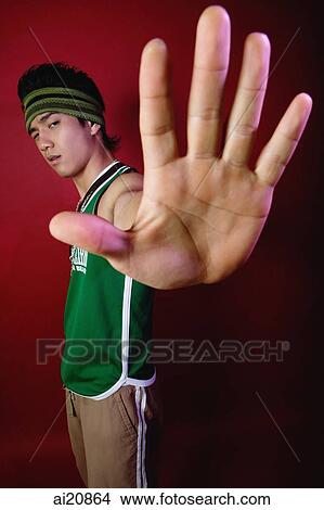 Picture - Young man with sweat band, showing palm of hand to camera. Fotosearch