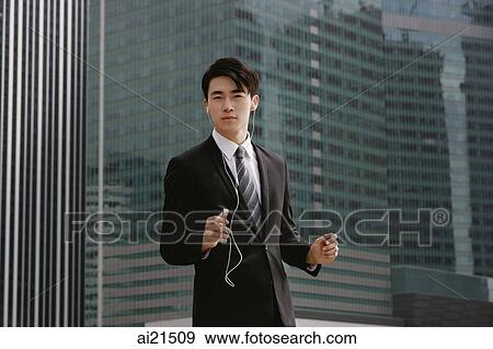 Businessman listening to MP3 player View Large Photo Image Stock Photo - Businessman listening to MP3 player. Fotosearch