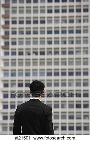 Businessman looking at building, rear view View Large Photo Image Stock Image - Businessman looking at building, rear view. Fotosearch