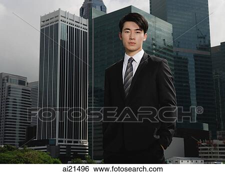 Businessman looking at camera, buildings in the background View Large Photo Image Stock Photograph - Businessman looking at camera, buildings in the background. Fotosearch