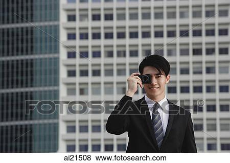 Businessman using camera phone View Large Photo Image Stock Photo - Businessman using camera phone. Fotosearch