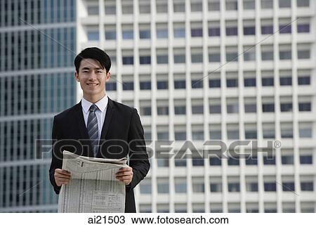 Businessman with newspaper, building behind him View Large Photo Image Stock Image - Businessman with newspaper, building behind him. Fotosearch