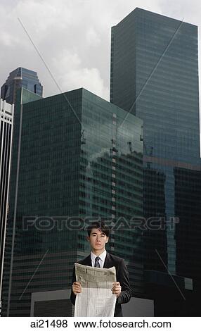 Businessman with newspaper, cityscape in the background View Large Photo Image Stock Photo - Businessman with newspaper, cityscape in the background. Fotosearch