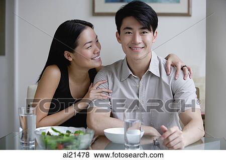 Couple at home, sitting by dining table, man looking at camera View Large Photo Image Stock Photo - Couple at home, sitting by dining table, man looking at camera. Fotosearch