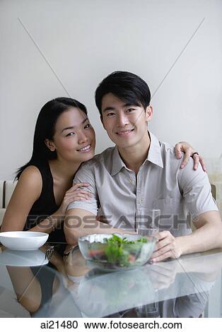 Couple sitting at dining table, looking at camera View Large Photo Image Stock Image - Couple sitting at dining table, looking at camera. Fotosearch