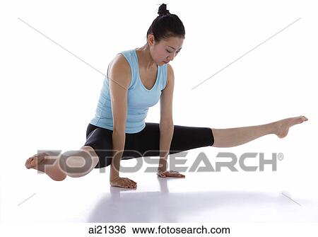 Stock Photograph - Female gymnast performing gymnastics in studio, balancing on two arms. Fotosearch