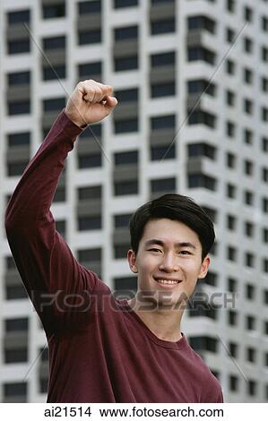 Man smiling at camera, hand raised in a fist View Large Photo Image Picture - Man smiling at camera, hand raised in a fist. Fotosearch