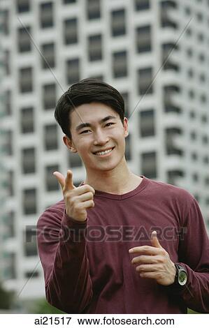 Man smiling at camera, making hand sign View Large Photo Image Stock Photo - Man smiling at camera, making hand sign. Fotosearch