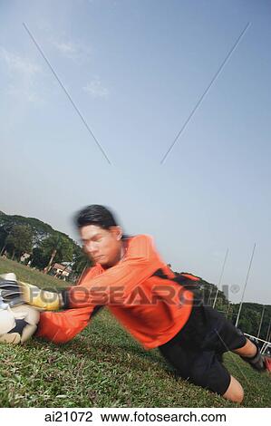 Stock Image - Soccer goalie lunging for ball. Fotosearch