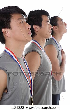 Stock Image - Three athletes in a row with medals around their necks. Fotosearch