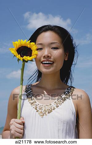 Woman holding sunflower stalk, portrait View Large Photo Image Stock Photo - Woman holding sunflower stalk, portrait. Fotosearch