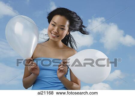 Woman holding two white balloons View Large Photo Image Stock Photo - Woman holding two white balloons. Fotosearch